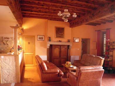 Salón con sofás de cuero y reproductor de DVD en mueble antiguo.